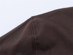 Detail of high-quality dark brown knitted T-shirt with neat stitching and cotton texture