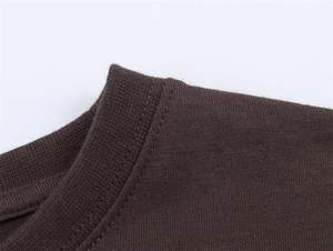 Detail of dark coffee brown t-shirt showing ribbed neckline and high-quality knit texture