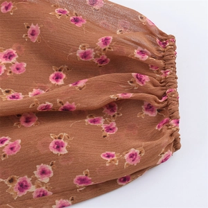 Detail of elastic cuff on brown chiffon blouse with pink floral pattern for women
