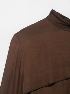 Detail of slim-fit dark brown turtleneck knit top showing shoulder seams and neckline