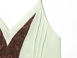 Detailed view of light green camisole with brown floral lace and V-neck pleated design