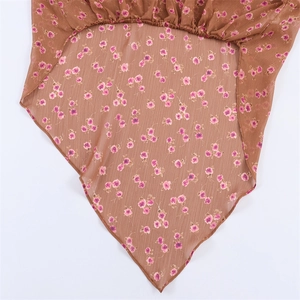 Detail of floral chiffon fabric with a V-shaped hem and pink flower patterns