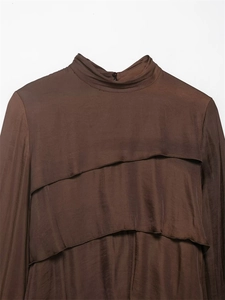 Close-up of dark brown long-sleeved top with mock neck and tiered ruffled details