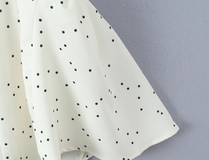 Détail du tissu à pois crème et noir montrant la texture légère et fluide