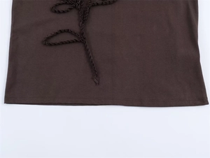 Detail shot of chocolate brown knit top featuring decorative 3D ruffled trim and texture