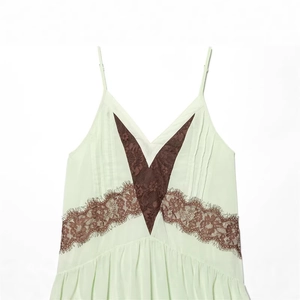 Detail of light green chiffon camisole with brown eyelash lace trim and V-neckline