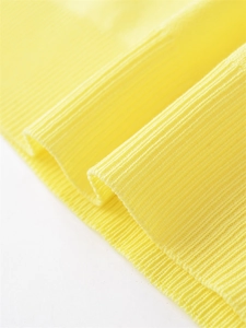 Détail macro de la texture du tissu en maille côtelée jaune vif avec tissage précis