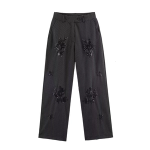Detail of high waisted pinstripe trousers featuring black sequin floral embroidery