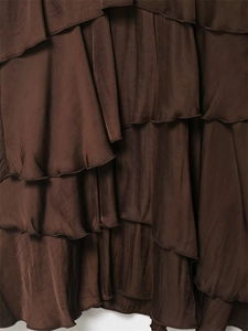 Detailed macro shot of dark brown tiered ruffles and silk texture on slim fit dress