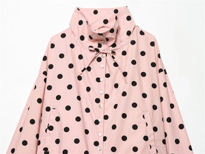 Detail of pink polka dot jacket with high funnel neck and pearl luster buttons