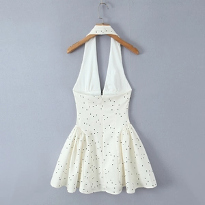 Détail de la mini robe dos nu à pois avec décolleté en V et jupe à volants sur cintre