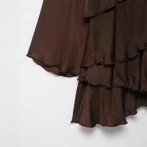Detailed macro view of dark brown satin tiered ruffle layers on a slim fit casual dress