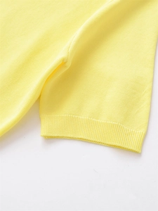 Vue détaillée de la maille côtelée jaune et de la couture premium à l'épaule du pull