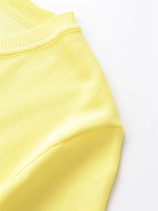 Gros plan détaillé du pull en tricot jaune avec col côtelé et texture douce du tissu