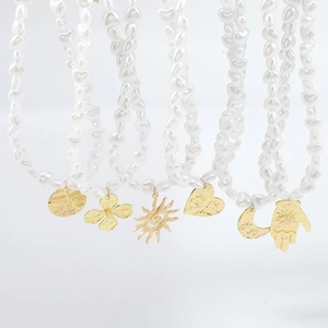 Detailed shot of French vintage necklaces with heart-shaped pearls and gold charms