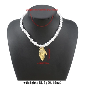 Detailed view of French vintage heart pearl necklace with golden Hamsa hand pendant