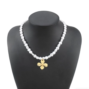 Elegant French vintage pearl necklace with textured gold clover pendant on model