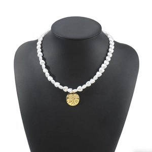 Detailed close-up of a French vintage heart pearl necklace with a gold coin pendant