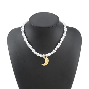 Detailed close-up view of a vintage white heart pearl necklace with a gold moon pendant