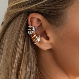 Macro view of multi-layer gold and silver ear cuffs with rectangular gemstones