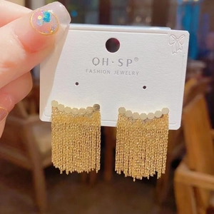 Exaggerated gold tassel earrings with curved metal top on card holder for women