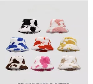 Vista piatta di cappelli a secchiello colorati in ecopelliccia con stampa mucca da donna