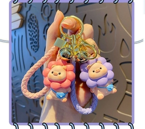Close-up of cute resin pig keychains with floral headwear and colorful woven leather straps