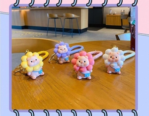 Close-up of colorful cartoon pig sunflower keychains with braided wrist straps