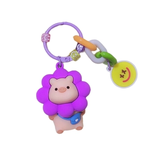 Pink pig keychain with purple sunflower, colorful chain, and yellow smiley charm on white base