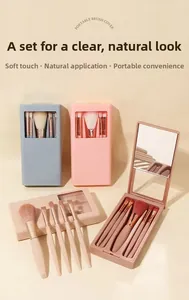 Detail of five makeup brushes in a portable case with built-in mirror and window