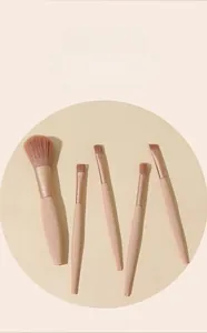 Detailed set of 5 pink makeup brushes with soft brown bristles on a warm background