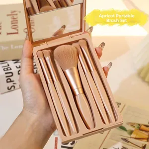 Detail of five-piece portable makeup brush set with mirrored apricot storage case
