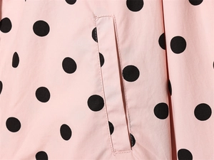 Detailed view of pink polka dot jacket featuring side pocket and premium stitching
