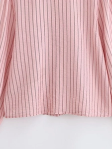 Detailed close-up of pink vertical striped fabric texture and hem stitching on summer shirt