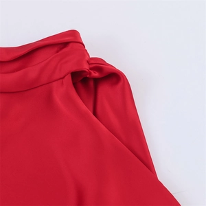 Vue macro d'une robe en satin rouge avec drapé d'épaule élégant et détails plissés