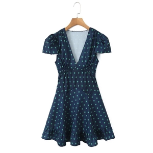 Detail of deep V-neckline with scalloped trim and green floral print on navy summer dress