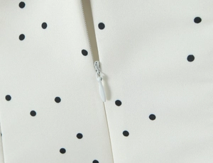 Gros plan détaillé sur la fermeture éclair invisible d'une robe d'été à pois
