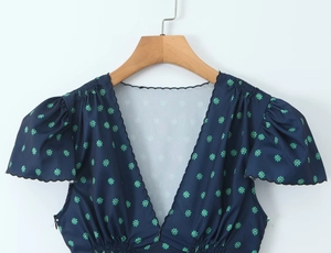 Detail of V-neckline with wavy stitching and floral print on navy summer dress
