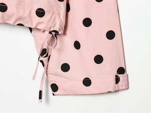 Detail of pink polka dot jacket with black spots, drawstring, and precision stitching