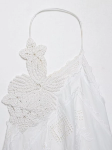 Close-up of white crochet leaf decor and floral embroidery on bohemian style top