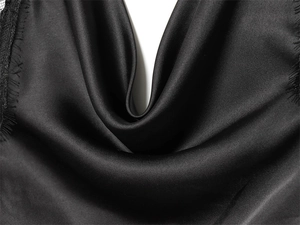 Close-up of black satin fabric detail showing premium silky texture and glossy finish