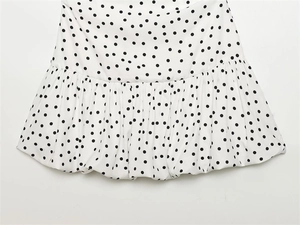 Détail du tissu blanc à pois noirs avec ourlet à volants multicouches de la robe