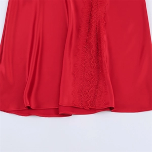 Vue détaillée de l'ourlet en satin rouge avec bordure en dentelle de cils délicate