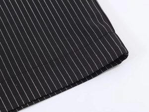 Detailed close-up of high-quality black pinstripe fabric with durable stitched hemline