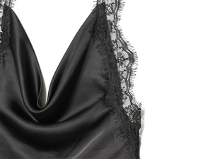 Detailed close-up of the black satin camisole featuring delicate eyelash lace trim on the neckline