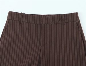 Close-up of waist detail and pockets on brown pinstripe trousers with belt loops