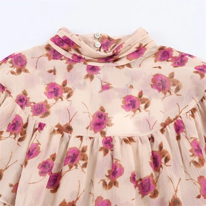 Detail view of the retro ruffled high collar and purple floral print on casual shirt