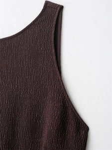 Macro detail of dark brown dress fabric showing textured ripple seersucker and fine stitching