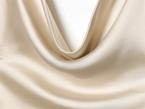 Detailed macro view of champagne satin fabric with elegant cowl neck draped folds