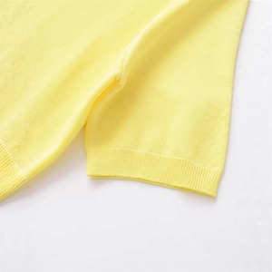 Gros plan d'un pull en maille jaune clair avec des poignets côtelés et une texture fine